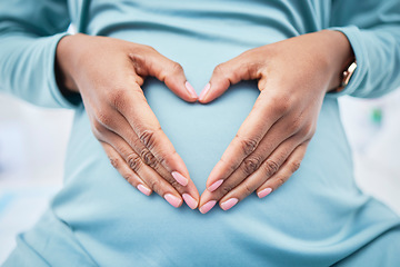 Image showing Heart, woman hand and pregnancy love in a hospital with mama, stomach and baby care. Wellness, abdomen and pregnant female person with emoji and happy mom gesture of a check for health of a mother