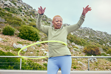 Image showing Senior fun, game and black woman with a hula hoop for sports, exercise or cardio in nature. Happy, elderly and an African person training with a toy for a workout, recreation or hobby on the weekend