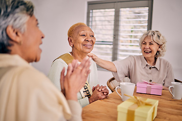 Image showing Senior friends, birthday singing and party at a home with a present and gift with excited people. Surprise, celebration and retirement of elderly group at a dining room table together with a smile