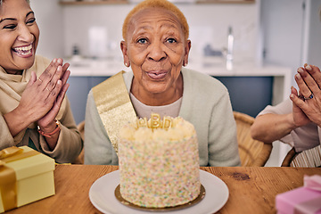 Image showing Senior woman, blowing candle and cake portrait at a birthday party or event with clapping and excited. Elderly friends, smile and laughing in retirement and nursing home with celebration and fun