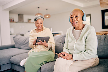 Image showing Headphones, relax and senior women on sofa in home listen to music, audio and radio with friend. Retirement, technology and people in living room on tablet for streaming track, song or subscription