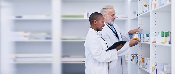 Image showing Discussion, tablet and pharmacists checking medication for inventory, stock or medical research. Healthcare, medicine and senior chemist mentor teaching female pharmaceutical student with technology.