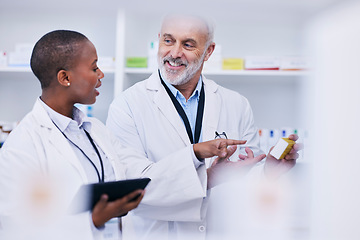 Image showing Conversation, tablet and pharmacists checking medication for inventory, stock or medical research. Healthcare, medicine and senior chemist mentor teaching female pharmaceutical student with tech.