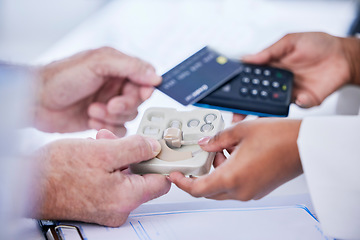 Image showing Doctor, hands and patient with credit card in payment for hearing aid, sound or consultation at clinic. Closeup of person paying on pos or electronic machine for ear device in audiology at hospital