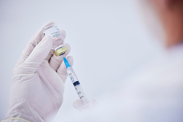 Image showing Vaccine bottle, needle and hands of doctor for safety, healthcare and pharmaceutical medicine. Closeup, virus injection and nurse prepare vaccination with vial, medical drugs and immunity in clinic