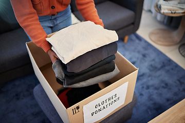 Image showing Donation box, charity and hands with clothes for nonprofit and cardboard container at home. Moving, donating and house with giveaway and spring cleaning for community care support with packing