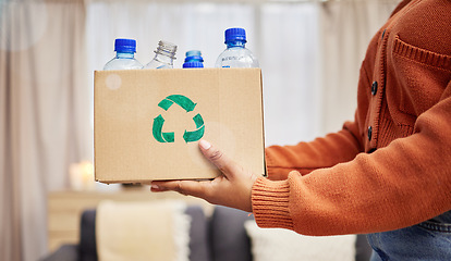 Image showing Plastic, recycle and hands with bottle in box in living room for eco friendly, reuse and renewable litter. Sustainability, conservation and person with container to reduce waste, litter and garbage