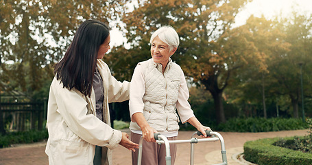 Image showing Park, walker and woman help senior walking as support, trust and care for morning healthcare exercise or workout. Health, physical therapy and elderly with caregiver for outdoor rehabilitation