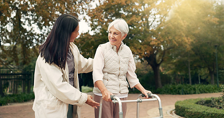 Image showing Park, walker and woman help senior walking as support, trust and care for morning healthcare exercise or workout. Health, physical therapy and elderly with caregiver for outdoor rehabilitation