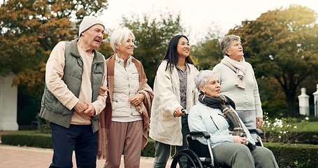 Image showing Retirement, walking and senior friends in park for bonding, wellness and quality time together outdoor. Wheelchair, nature and elderly man and women with caregiver for fresh air, health and relax