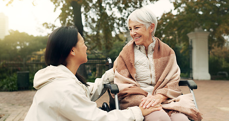 Image showing Wheelchair, park and a senior woman with a disability talking to her nurse during a walk together outdoor. Healthcare, medical and a female care chatting to an elderly patient or resident in a garden