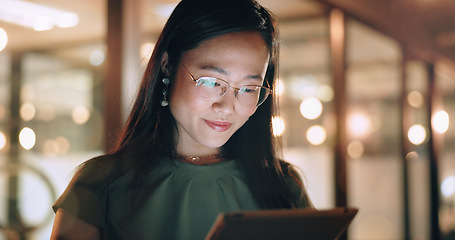 Image showing Woman, tablet and reading in night at office, focus or happy for social media app, chat or email. Asian web expert, digital marketing and working on strategy, tech business or social network in Tokyo