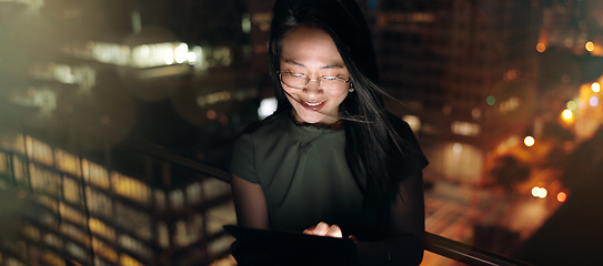 Image showing Woman, digital tablet and rooftop at night in city for social media, research and networking on urban background. Business woman, balcony and online search by entrepreneur working late in New York