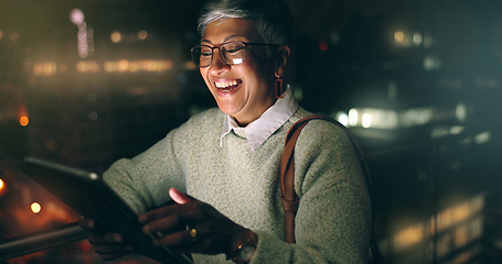 Image showing Night, tablet and business woman laughing at comic meme or joke after finishing project. Social media, mature and happy female employee typing on touchscreen after working late in dark workplace.