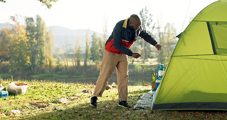 Image showing Camping, tent and black man setup in nature for shelter on outdoor holiday, vacation and adventure, Campsite, traveling and male person with hammer for pins for gear in woods, forest and countryside