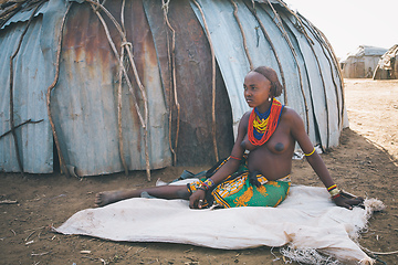 Image showing Dasanesh woman resting in shadow of hut, Omorate, Omo Valley, Ethiopia