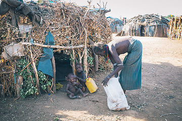 Image showing Dasanesh woman with children in front of his hut. Omorate, Omo Valley, Ethiopia