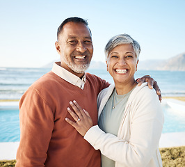 Image showing Senior couple, hug and portrait at the beach, love and care with bonding, travel and trust in a marriage. Life partner, ocean and adventure in nature, people on holiday with retirement and happiness