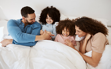 Image showing Home bedroom, happy children and parents relax, laugh and bond with kids, rest and enjoy quality time together. Bed, youth and top view of mother, father or family wellness, love and morning care