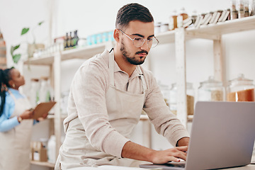 Image showing Man, small business and store for typing, laptop and notes with stock, supply chain and thinking with sustainable ideas. Entrepreneur, partnership and inventory checklist for product, woman and shop