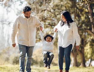 Image showing Outdoor, parents and kid holding hands, love and fun with bonding, weekend break and walking. Happy family, mother and father with child, playful or adventure in a park, freedom and swing with energy