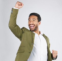 Image showing Happy asian man, fist pump and celebration in winning, success or promotion against a white studio background. Excited businessman smile in happiness for bonus, good news or victory with mockup space