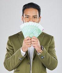 Image showing Asian man, money fan and finance in savings, investment or loan against a white studio background. Portrait of businessman with cash or dollar bills in financial freedom, profit or salary increase