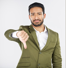 Image showing Sad, portrait and man with thumbs down in studio for rejection, no or bad review on grey background. Face, frown and Japanese model with emoji finger for negative, vote or feedback fail or opinion