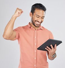 Image showing Happy asian man, tablet and fist pump in winning, celebration or promotion against a white studio background. Excited male person with technology app in happiness for victory, success or good news