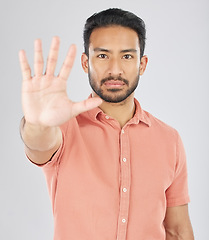 Image showing Stop, hand and portrait of asian man in studio with warning, control or protection order on grey background. Protest, palm and face of Japanese male model with no, emoji and limit, ban or threat sign