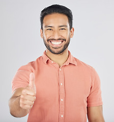 Image showing Happy asian man, portrait and thumbs up in good job, winning or success against a white studio background. Male person smile with like emoji, yes sign or OK in agreement, thank you or approval