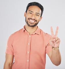 Image showing Peace, hands and portrait of happy man in studio for thank you, vote or feedback on grey background. V, sign and Japanese guy face with good vibes, smile or freedom emoji, support or self love