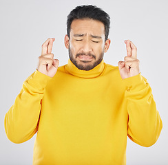 Image showing Nervous, face and fingers crossed by asian man in studio with anxiety for news, feedback or review on grey background. Hand, emoji and Japanese guy with anxious for results, competition or giveaway