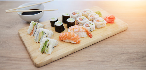 Image showing Sushi, seafood and wood board, soy sauce and closeup, salmon and rice with avocado, healthy and luxury. Japanese cuisine, catering with lunch or dinner meal, chopsticks and food with nutrition