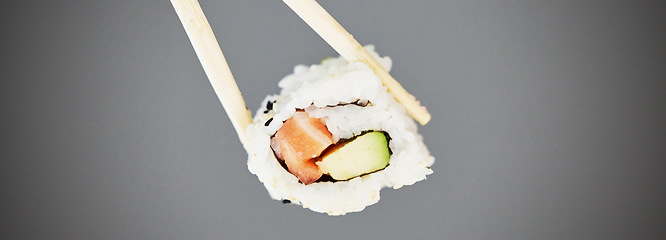 Image showing Seafood, sushi and chopsticks in studio, salmon roll isolated for healthy Asian dining promo. Japanese food culture with rice, raw fish and avocado, restaurant menu offer or deal on grey background.