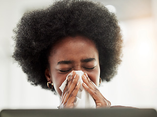 Image showing Allergies, sneeze and sick black woman blowing nose in home office with allergies, flu or cold in her home. Tissue, paper and African female freelancer with virus, hayfever or covid working on laptop
