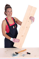 Image showing woman carpenter holding wooden plank 