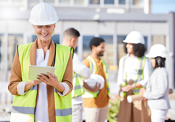 Image showing Tablet, architecture and a senior woman construction worker on a building site with her team in the city. Technology, planning and safety with a female engineer reading a blueprint on the internet