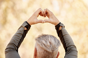 Image showing Nature, heart shape and back of man in a park for race, marathon or competition run training. Fitness, sports and closeup of an elderly male athlete with a love hand gesture in an outdoor garden.