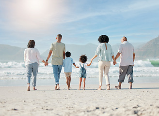 Image showing Back, beach and family holding hands, walking and summer vacation with bonding, love and travel. People, grandparents and mother with father, children and kids with seaside holiday, ocean and care