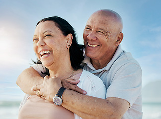 Image showing Hug, happy and thinking couple at beach for travel, vacation and at the ocean together. Smile, love and a senior man and woman with care and an idea at the sea in the morning, laughing and on a date