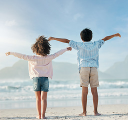 Image showing Kids, playing and airplane on beach, vacation or freedom on holiday in summer in Brazil with ocean, blue sky and happiness. Girl, boy and children play game as plane to fly for fun, bonding together