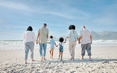 Image showing Family, holding hands and relax outdoor on a beach with love, care and happiness for summer vacation. Behind, space in sky or travel with men, women and children together at sea for holiday adventure