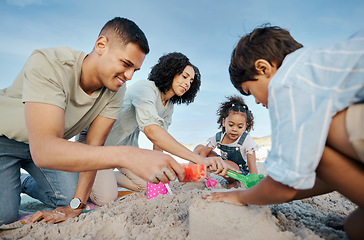 Image showing Parents, children and sandcastle at beach, bucket and digging for bonding, outdoor and vacation in summer. Mother, father and kids with plastic toys, sand and games on holiday, teamwork and ocean