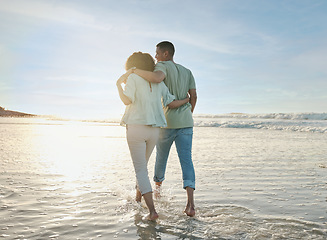 Image showing Love, hug and back of couple at the beach walking, bond and relax in nature on blue sky background. Ocean, love and rear view of man embrace woman at sea for travel, freedom and romantic walk in Bali