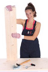 Image showing woman carpenter holding wooden plank