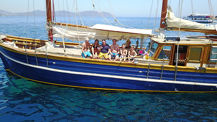 Image showing Group of people on boat, sailing in Greece and summer sun on ocean holiday, relax in freedom and nature. Yacht vacation, family travel and tropical cruise on sea adventure to Greek island on blue sky