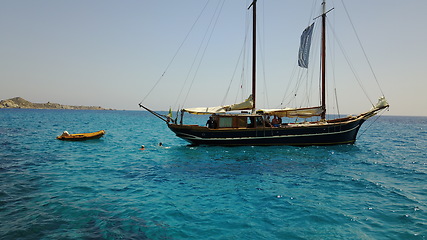 Image showing Yacht, sailing in Greece and summer on ocean holiday, relax in freedom and people swimming in blue water. Boat vacation, travel in sun and tropical cruise on sea adventure with island beach fun.