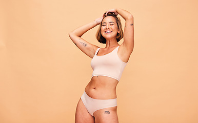 Image showing Happy, lingerie and body of woman in studio isolated on a brown background mockup space. Smile, underwear and model in natural beauty, self love and confidence for positivity, health and wellness