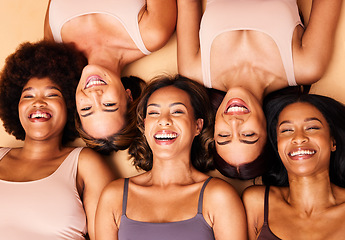 Image showing Diversity, beauty and portrait of women from above with smile, self love and solidarity in studio. Happy face, group of friends on beige background with underwear, skincare and cosmetics on floor.